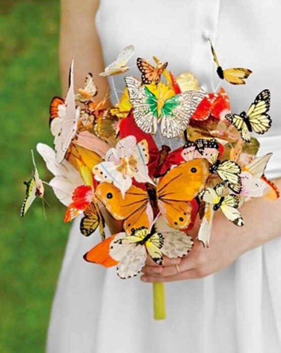 bride with a bouquet made with butterflies in shades of yellow and orange 