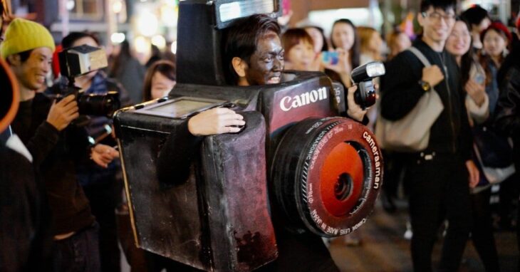 hombre disfrazado de cámara fotográfica