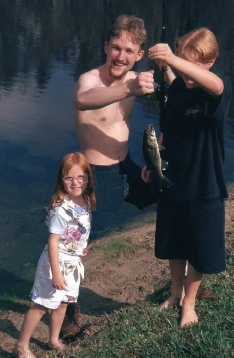 Hombre pescando junto a sus hijos al orilla de un lago
