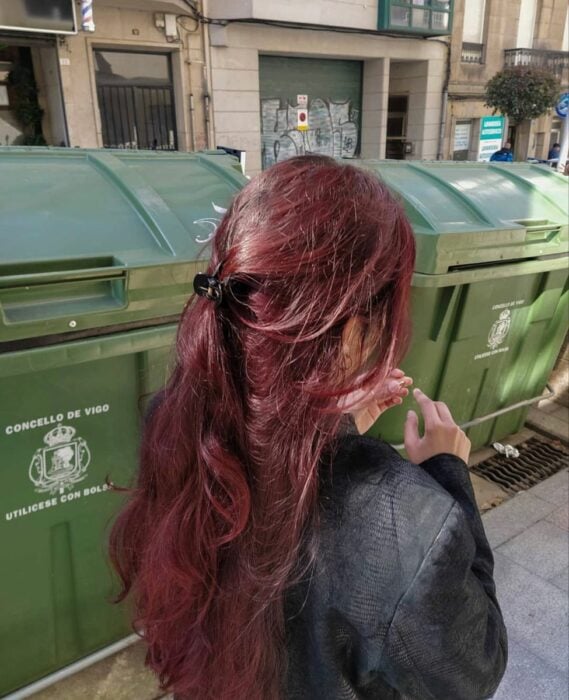 photo of a girl showing off her wine-colored hair under the sun's rays 