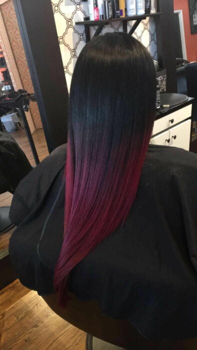 mujer de espaldas con las puntas del cabello pintadas en color vino tinto 