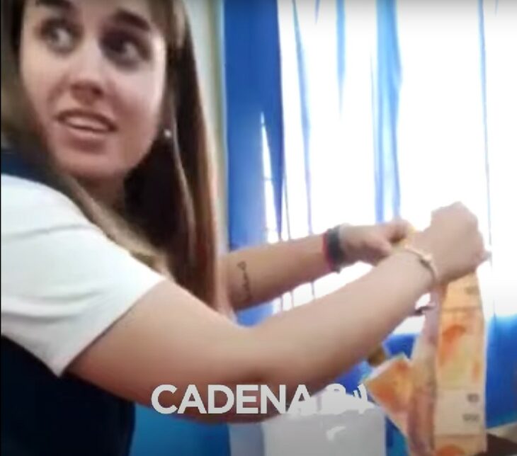 mujer sacando dinero del relleno de un pastel 