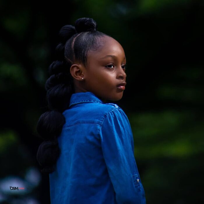 photograph of a Nigerian girl posing in a blue denim blouse 