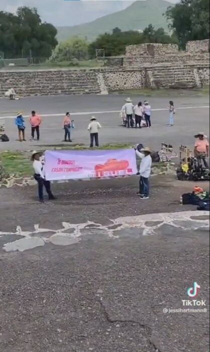 personas sosteniendo una lona con la que una chica le pidió matrimonio a su novio en Teotihuacán 
