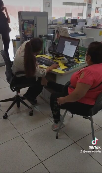 mujer sentada en una sucursal de Banco Azteca