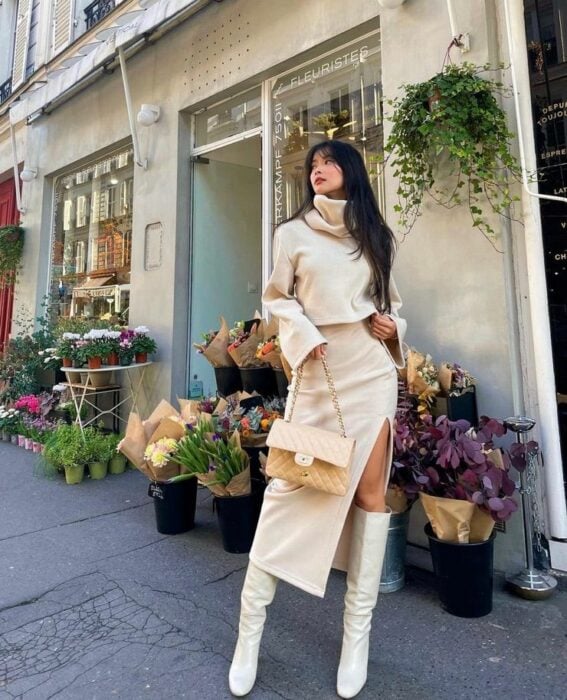 woman posing in front of a flower shop with open skirt and turtleneck sweater 