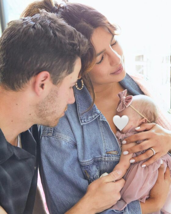 Photograph of Nick Jonas with his wife Priyanka Chopra carrying their daughter Malti Marie