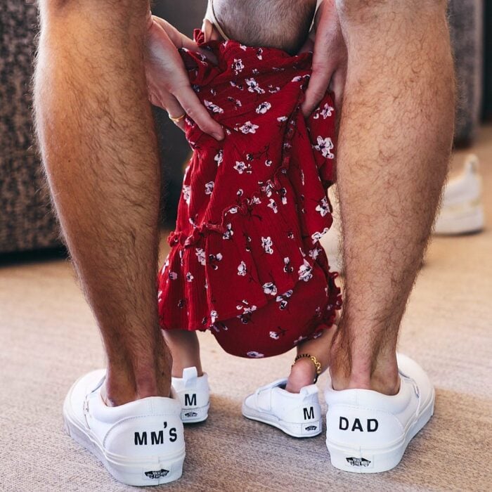 Fotografía que muestra los pies de Nick Jonas cargando a su pequeña hija Malti Marie
