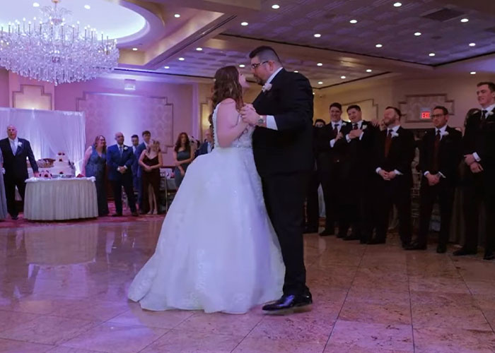 pareja de recién casados bailando en el centro de la pista de baile rodeados de sus invitados 