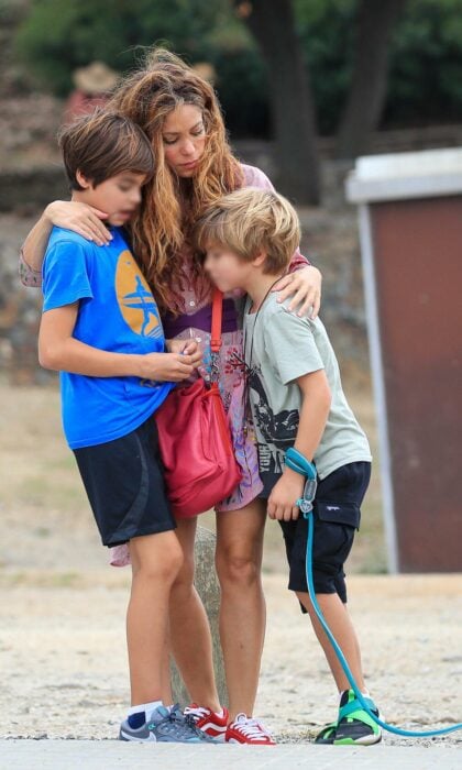 Photograph of Shakira hugging her children on the beach 