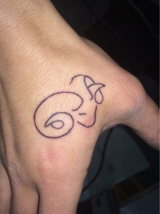 tattoo on a hand that tries to be a symbol of the zodiac sign capricorn 