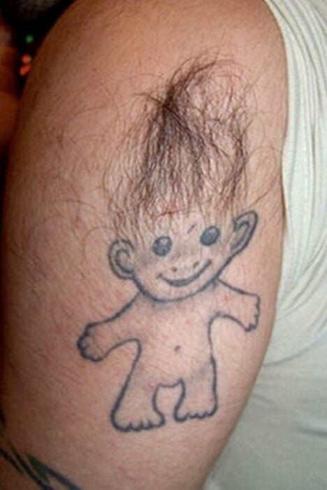 Troll figure tattoo on arm with pubic hair 
