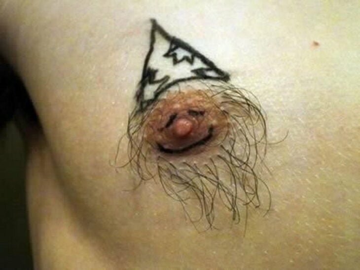 nipple surrounded by beauty with a face and wizard hat tattoo around the nipple 