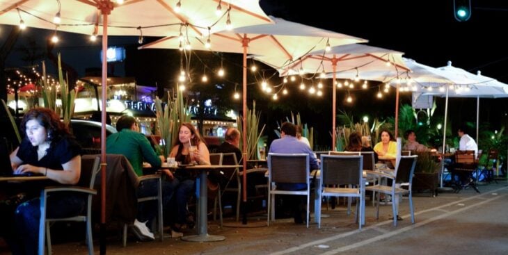 Personas comiendo en un restaurante al aire libre