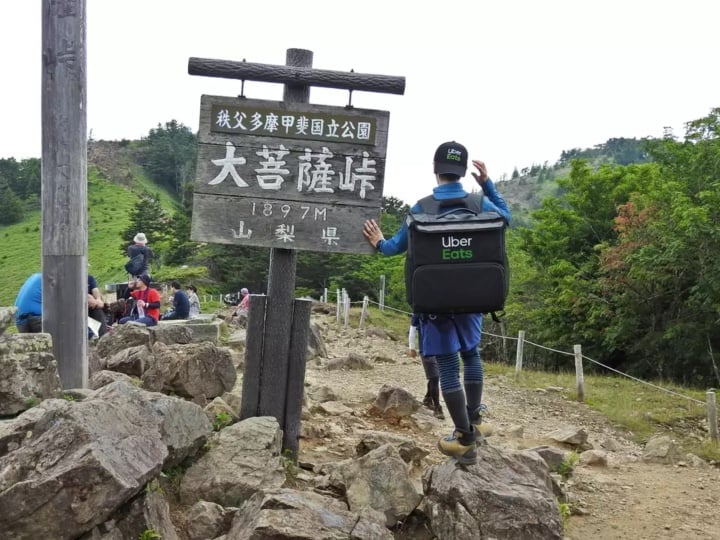raprtidor de pizza con mochila de uber en el monte Fuji