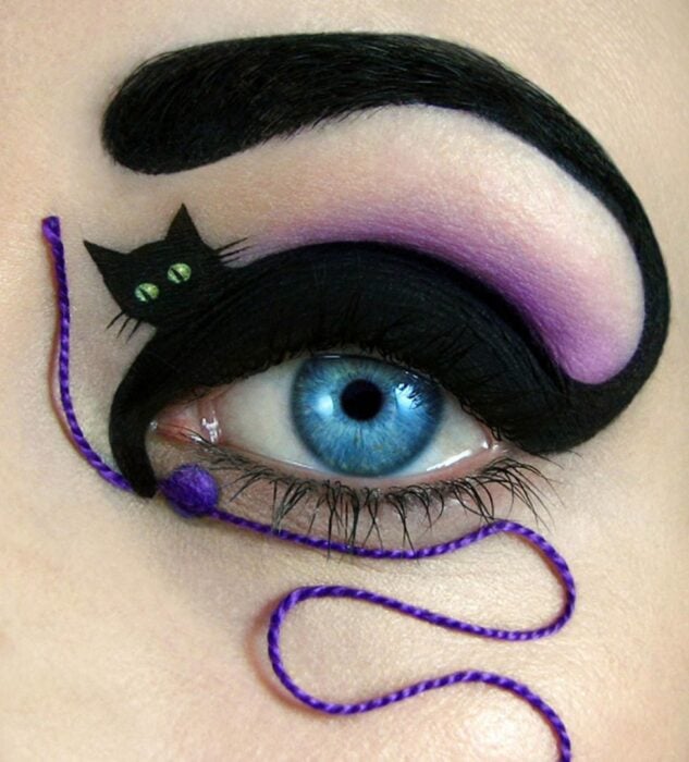 foto de un ojo delineado con un gato negro sosteniendo un estambre en color morado 