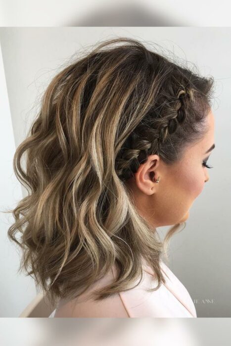 mujer posando un lado de su cabella mostrando la diadema hecha con una trenza en su cabello 