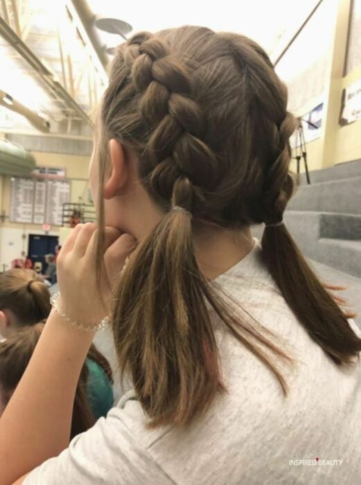 chica mostrando un par de trenzas tipo boxeadora 