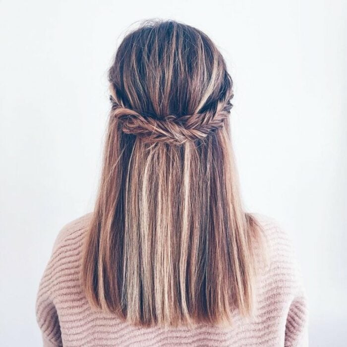 espalda de una chica mostrando un peinado hecho con un par de trenzas agarradas en la parte de atrás 