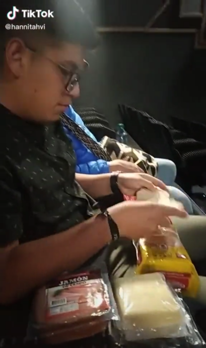 captura de pantalla de un joven preparando un sándwich en plena sala del cine. 