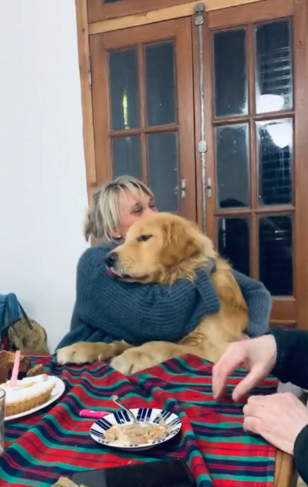 mujer abraza a perro golden