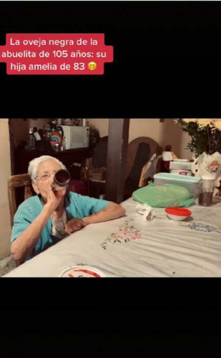 foto de una mujer tomando cerveza sentada frente a un comedor 