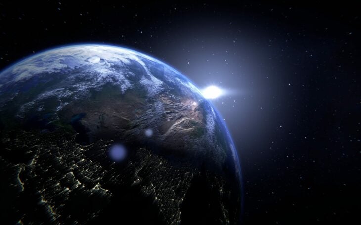 imagen del planeta tierra desde el espacio con un destello de luz 