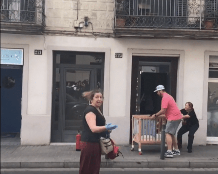 hombre sacando una cuna fuera de un edificio