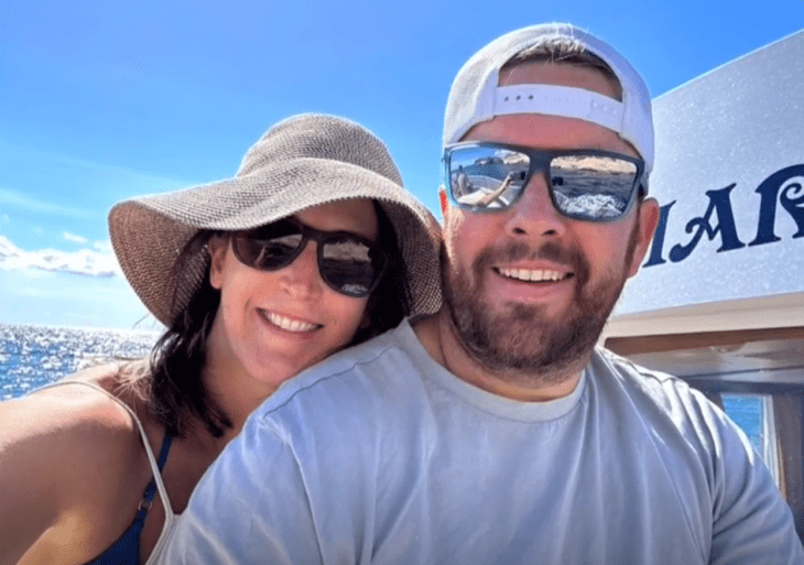 una pareja de turistas con lentes, gorra y sombrero