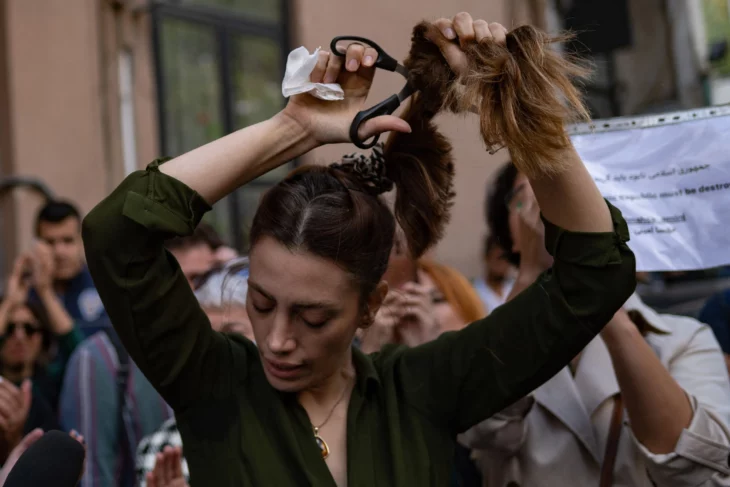 Mujer cortándose el cabello como protesta por la muerte de Mahsa Amini