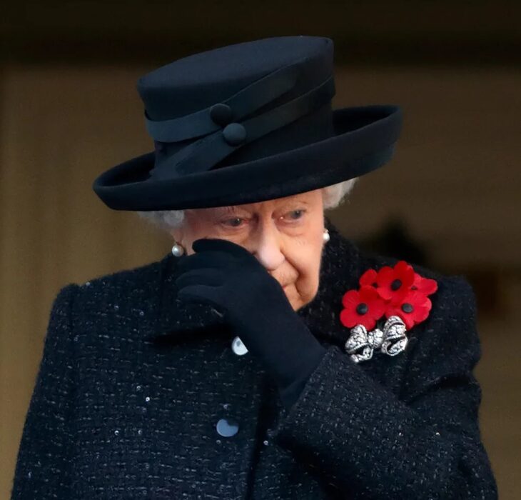 Queen Elizabeth II in mourning clothes wiping away tears at the funeral of her husband Prince Philip