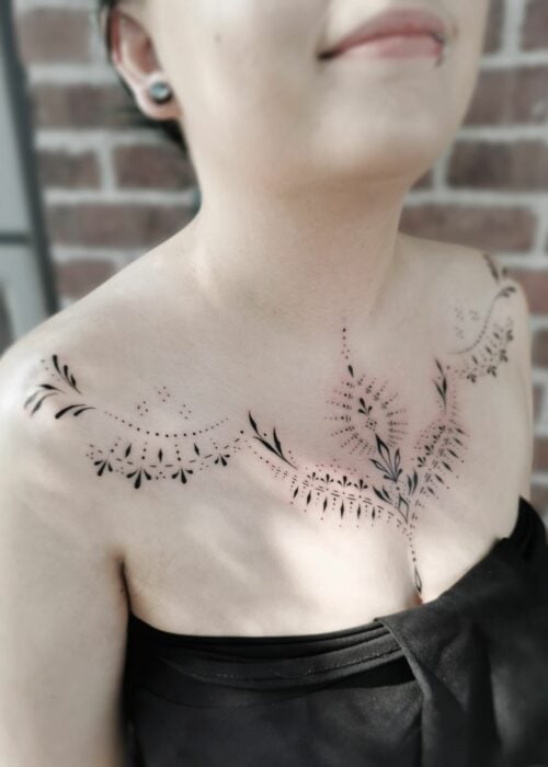 foto de una chica mostrando el tatuaje de collar hombro a hombro que luce en su pecho 