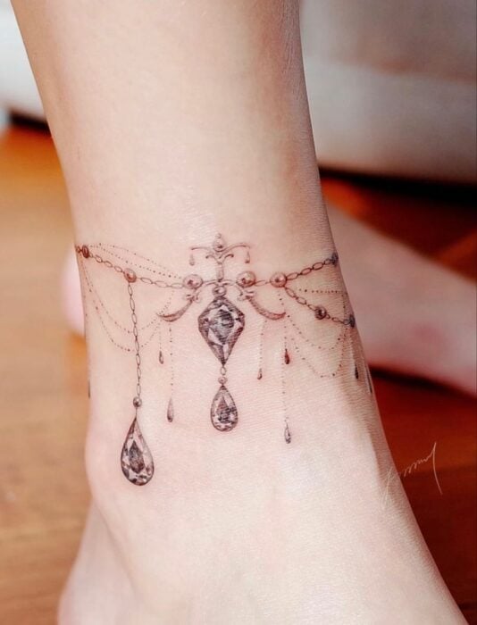 foto del tatuaje de una pulsera con diamantes en el tobillo de una persona 