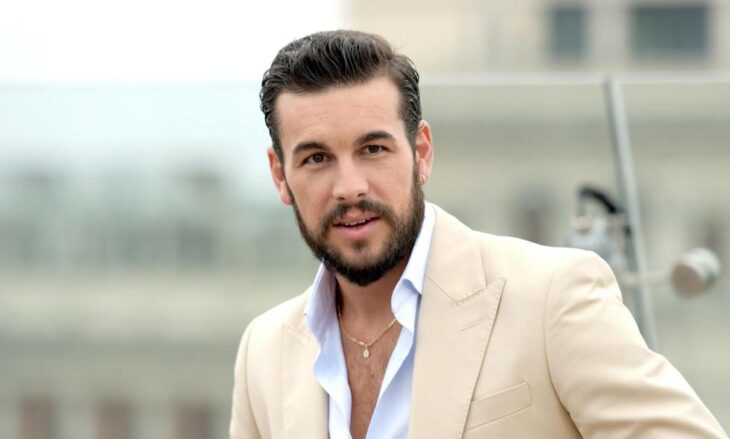 Mario Casas con saco color beige en exterior