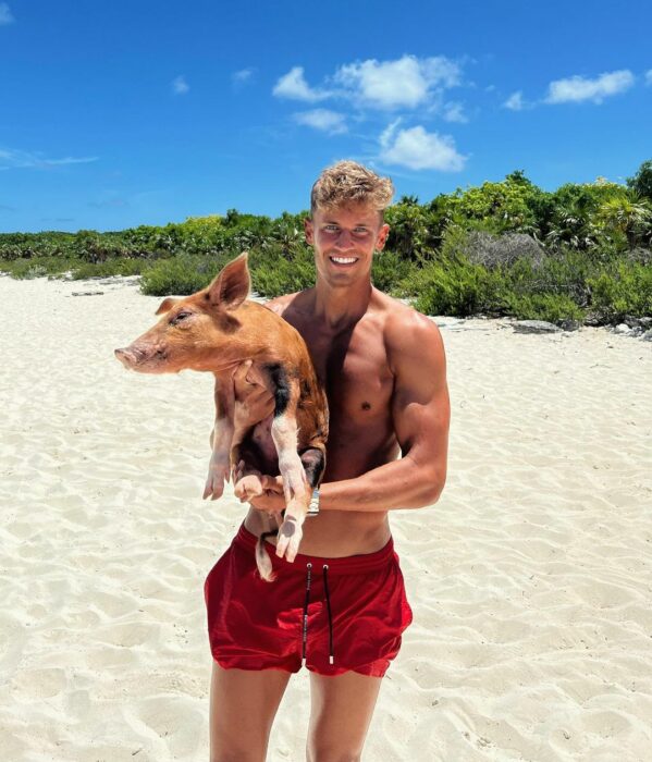 Marcos Llorente posando en la playa con un cerdito