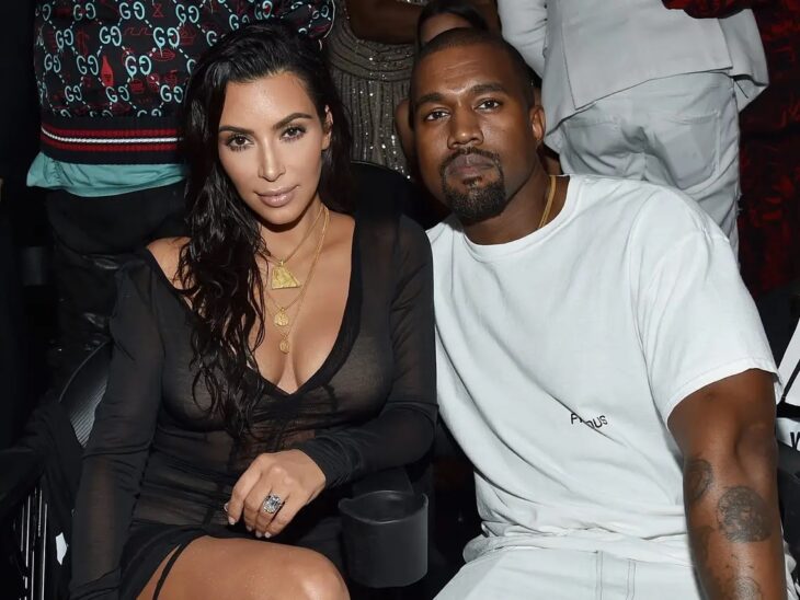 Kim Kardashian and Kanye West "Ye" sitting at a public event 