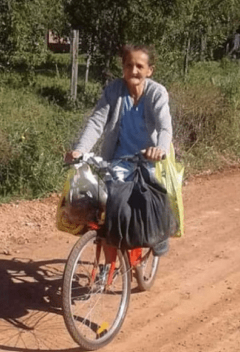 abuelita montando bicicleta por una calle de terracería