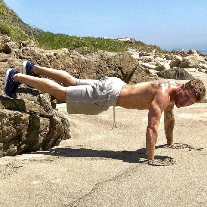 Ryan Phillipe realiza un duro entrenamiento en la playa con una serie de lagartijas lleva el torso sin camisa y un short gris con tenis negros