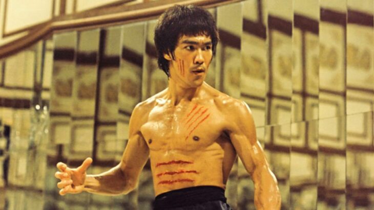 Bruce Lee está en la escena de una de sus películas trae varios rasguños en el cuerpo, no lleva camisa sólo un pantalón holgado negro