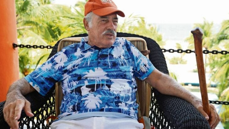 Photograph of the actor Andrés García sitting in a chair facing the sea in his house on the beach 
