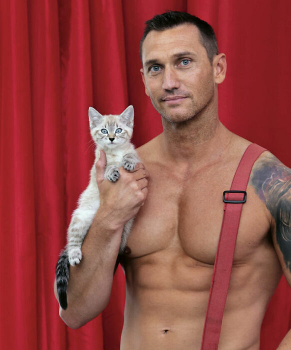 bombero posando para calendario con un gatito de ojos azules 