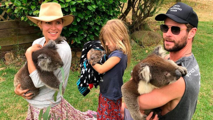 el actor Chris Hemsworth con su familia disfrutando de unas merecidas vacaciones todos traen en brazos pequeños koalas de color café y vistan de forma casual su esposa lleva un sombrero claro para el sol y el actor lleva una gorra