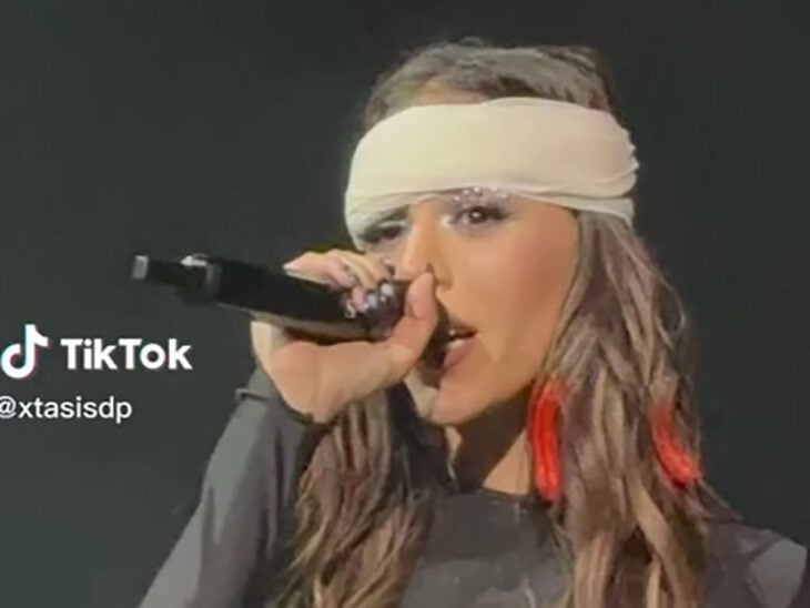 singer Danna Paola with a bandage on her head performing one of her hits