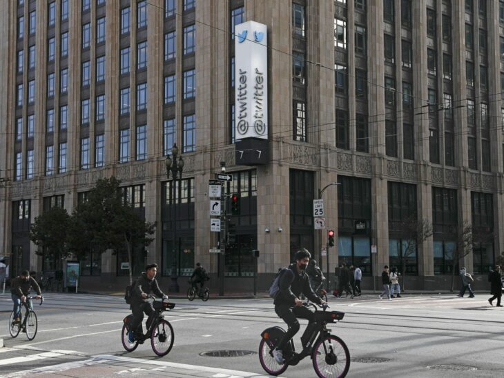Personas paseando en Bicicleta a las afueras de un edificio de Twitter 