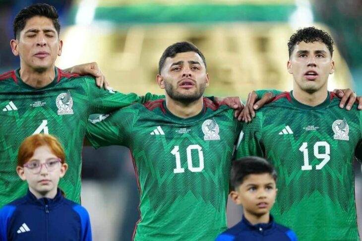 Photograph of three players from the Mexican soccer team with two children during their match against Poland at the Qatar 2022 World Cup