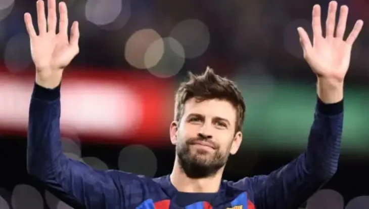 soccer player on the pitch, waving goodbye with raised arms, wears Barcelona team suit 