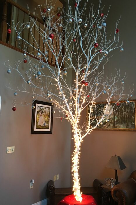 árbol de navidad hecho con una gran rama seca en color blanco con decoración en color blanco y rojo 