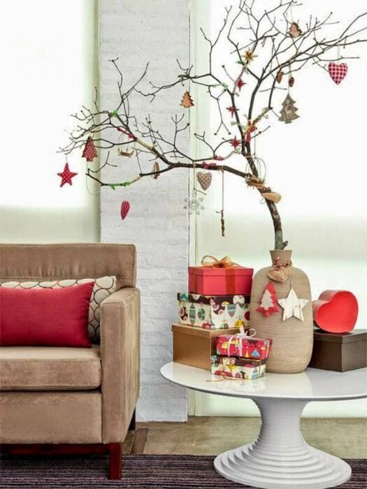 árbol de navidad con ramas secas sobre una mesa en la sala de una casa 