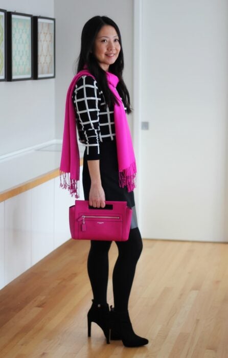 Mujer usando outfin negro y bufanda rosa