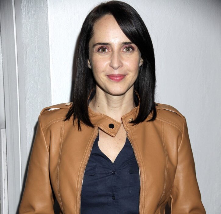 girl posing with brown leather jacket and navy blue blouse